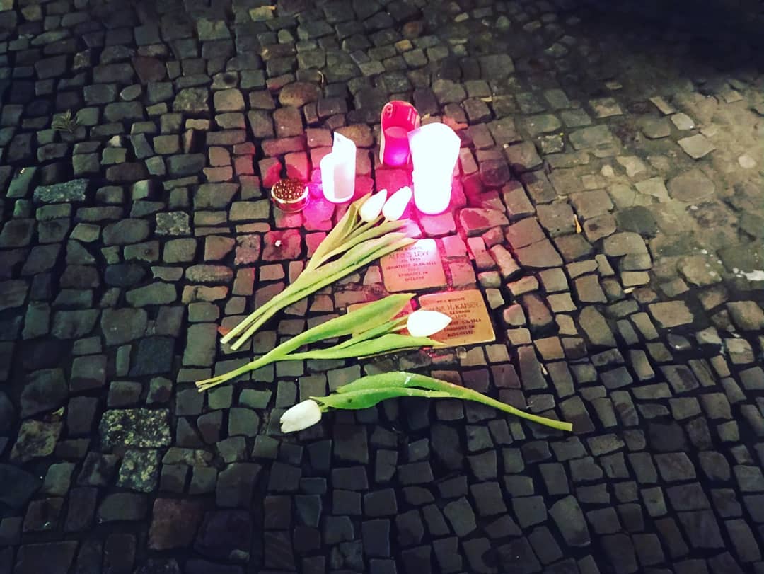 Las personas dejan velas en recuerdo de los asesinados por el nazismo en las placas del artista alemán Guter Demnig, Stolpersteine.