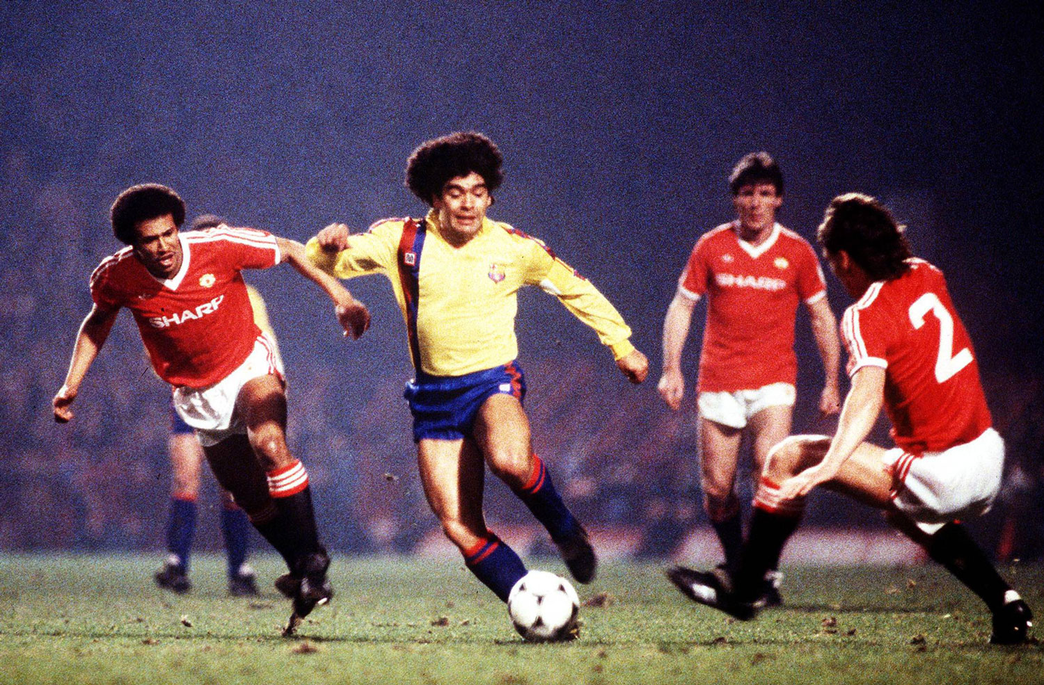 Maradona jugando para el Barcelona, gambeteando a Remi Mark Moses (izq.) y Mike Duxbury del Manchester United en el partido que perdería por 3 a 0 contra el Manchester United el 21 de marzo de 1984 por la Copa de Europa. Maradona nunca se pudo asentar en el equipo culé que terminó prescindiendo de él. ©imago/Colorsport.